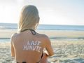 kobieta z napisem last minute na plecach na plaży