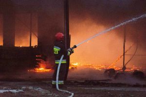 strażak gaszący płonący budynek