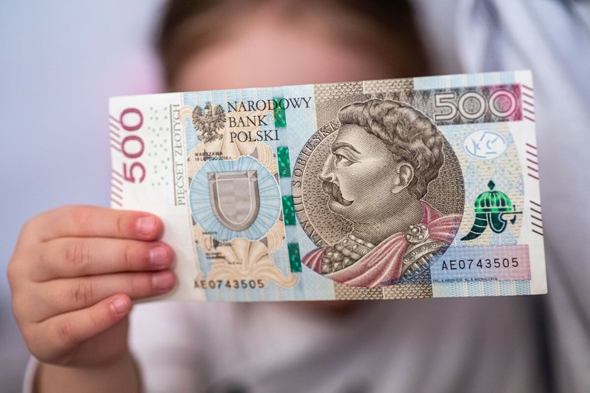 dziecko trzymające banknot 500 zł