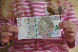 dziecko trzymające banknot 500 zł