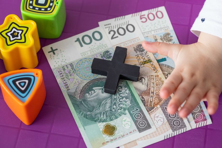 pieniądze, klocek plus i ręka dziecka