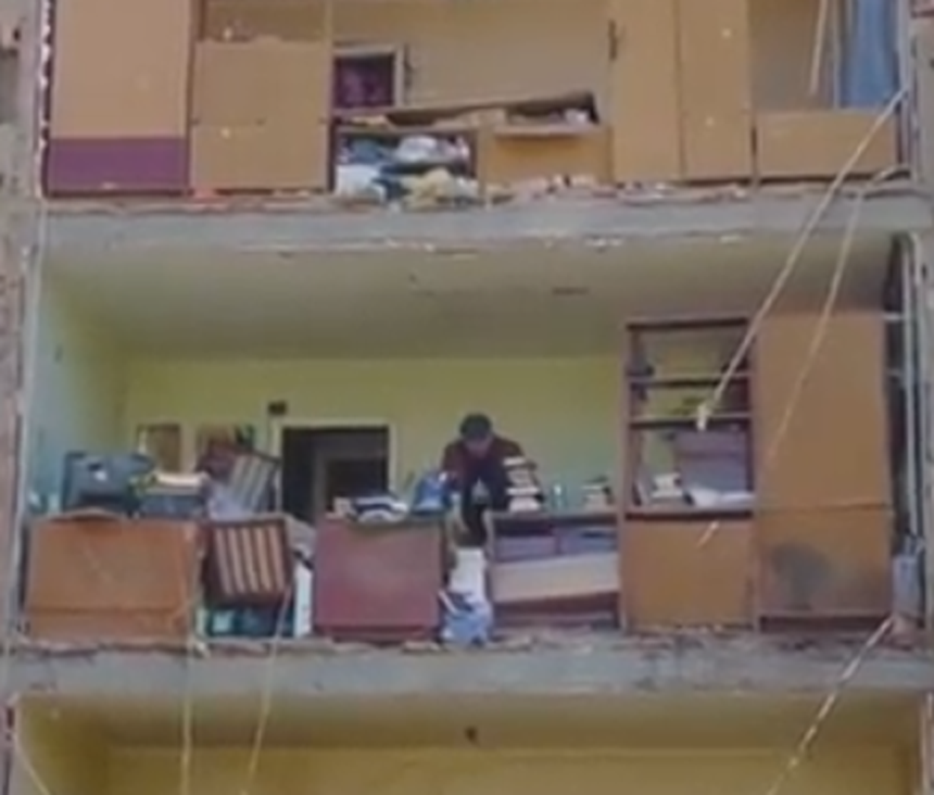 staruszek ratuje swoj dobytek po bombardowaniu