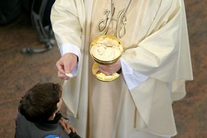 ksiądz udzielający komunii