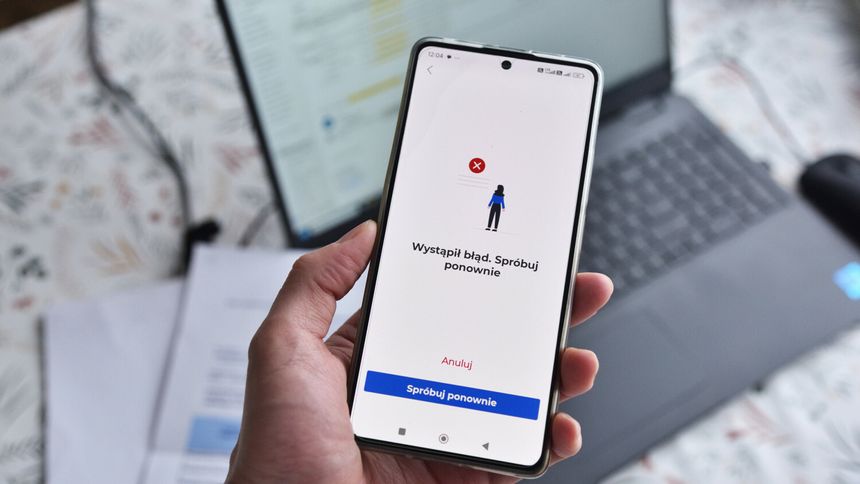 Smartfon na dłoni wyświetlający komunikat o błędzie