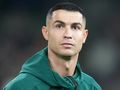 Cristiano Ronaldo w bluzie na boisku piłkarskim przed meczem.