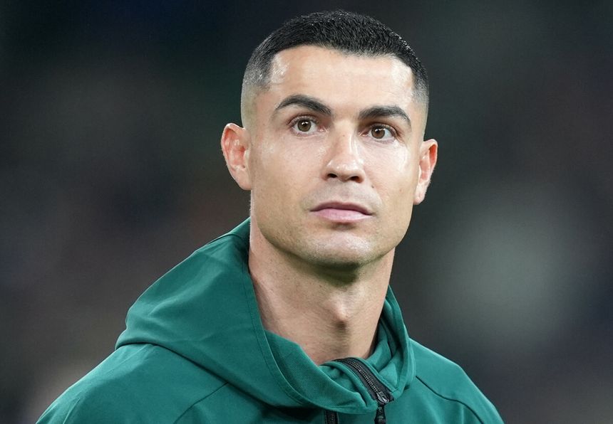 Cristiano Ronaldo w bluzie na boisku piłkarskim przed meczem.