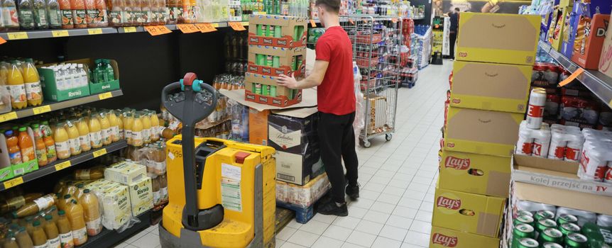 Pracownik wykłada towar w sklepie