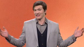 Connor Storrie w skeczu SNL na pomarańczowym tle