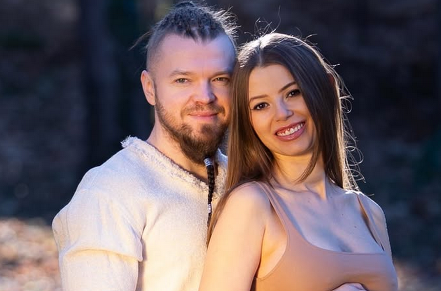Sylwester Wardęga wraz z partnerką pozują do zdjęcia.