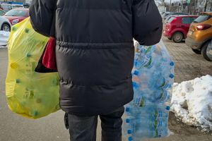 konsument niesie worki z opakowaniami do automatu kaucyjnego