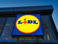 Logo sklepu Lidl na jasnym tle, umieszczone na ścianie budynku.