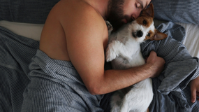 Mężczyzna śpi z psem