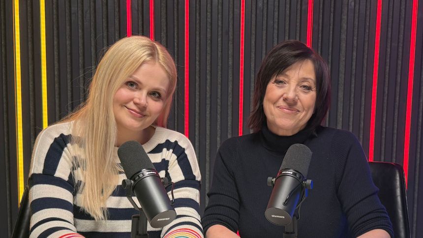 Dwie uśmiechnięte kobiety przy mikrofonach w studiu nagraniowym