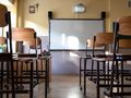 Pusta klasa szkolna z drewnianymi krzesłami, tablicą i rzutnikiem