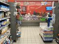 Zdjęcie przedstawia wnętrze sklepu spożywczego z regałami i ladą ze wędlinami.