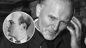 Zdjęcie przedstawia mężczyznę w sutannie, z charakterystycznym grymasem na twarzy. W tle zamazane.