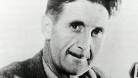 Człowiek w ciemnej marynarce, patrzący w obiektyw.