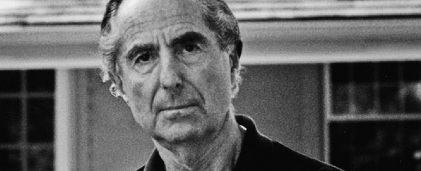 Mężczyzna z poważnym wyrazem twarzy, ubrany w czarną koszulę.