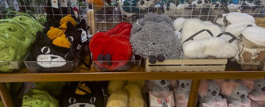 Na zdjęciu znajduje się półka z różnymi pluszowymi zabawkami w kształcie zwierząt.