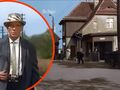Na zdjęciu widoczny mężczyzna w kapeluszu, stojący na tle domów. Scena z filmu