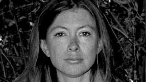 Portret kobiety z długimi włosami na tle zieleni.