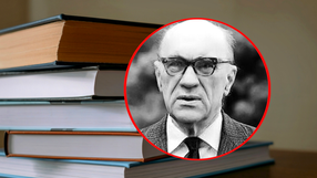 Na zdjęciu stos książek z czarno-białym portretem mężczyzny w okularach.