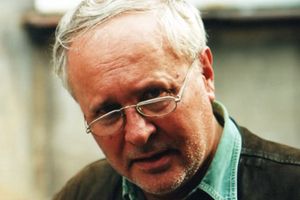 Osoba w okularach, z emocjonalnym wyrazem twarzy, ubrana w brązową kurtkę. Brak informacji o polityku.
