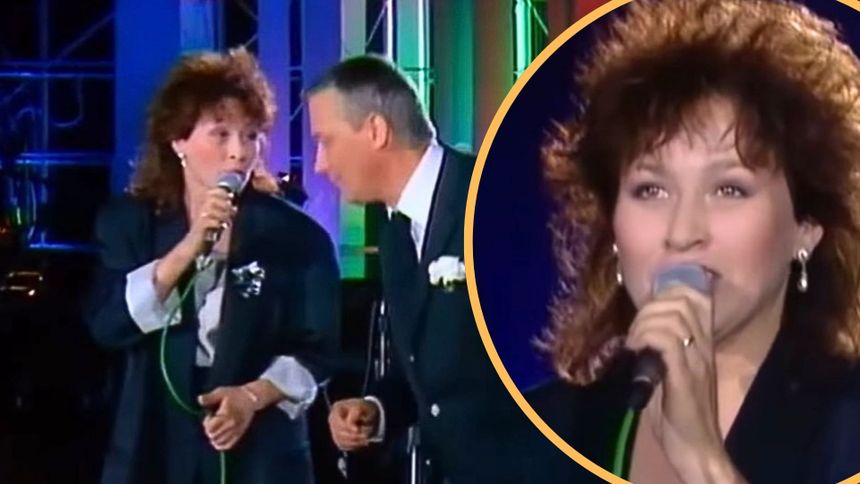 Na zdjęciu dwie osoby śpiewają duet, w tle kolorowe światła. Kobieta trzyma mikrofon, mężczyzna patrzy na nią.