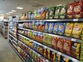 Aksamitne półki sklepu pełne kolorowych paczek chipsów różnych smaków.