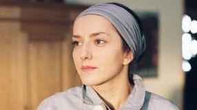 Portret młodej kobiety z chustką na głowie, patrzącej w dal w naturalnym świetle.