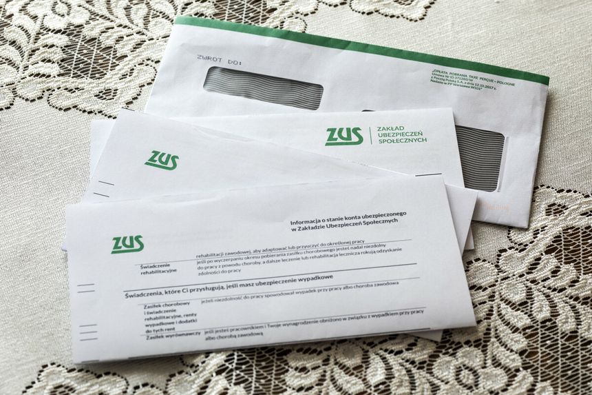 Na zdjęciu widać koperty z logo ZUS na koronkowym obrusie. Dokumenty dotyczą ubezpieczeń społecznych.