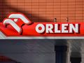 Logo stacji paliw Orlen z orłem na tle czerwonym, wyeksponowane na budynku.