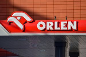 Logo stacji paliw Orlen z orłem na tle czerwonym, wyeksponowane na budynku.