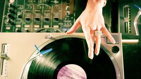 Na zdjęciu widać rękę DJ-a dotykającą płyty winylowej na gramofonie.