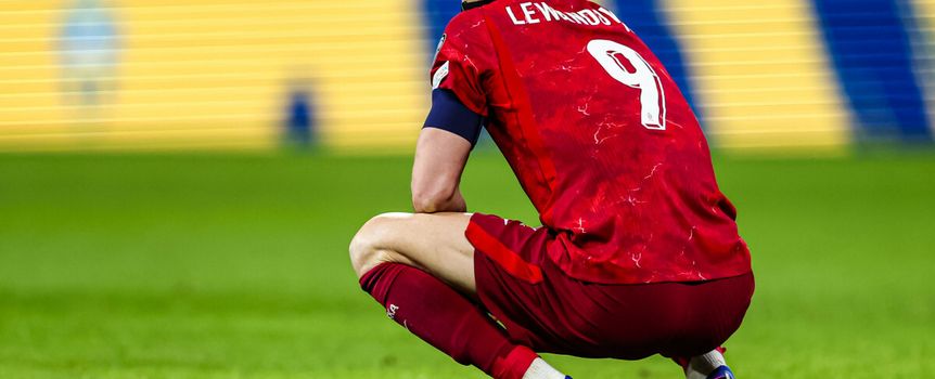 Robert Lewandowski klęczy na boisku po przegranym meczu ze Szwecją.