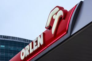 Zdjęcie przedstawia logo stacji benzynowej ORLEN na tle nieba.