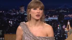 Kobieta w eleganckiej sukni z dekoltem, mówi w programie telewizyjnym, tło nocne miasta.