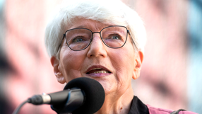 Małgorzata Musierowicz mówi do mikrofonu. Tło jest rozmyte.