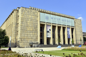 Muzeum Narodowe w Krakowie z ogrodem na pierwszym planie. Jasne niebo w tle.