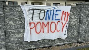 Na białym płótnie napis: 