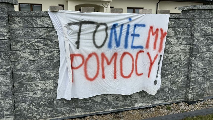Na białym płótnie napis: 