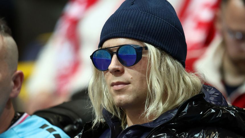 Konrad „Skolim” Skolimowski z długimi, blond włosami, w granatowej czapce i okularach przeciwsłonecznych.