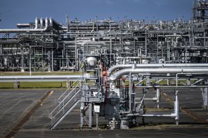 Złożona infrastruktura przemysłowa z metalowymi rurami i zasobnikami na tle nieba.