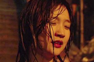 Zdjęcie przedstawia kobietę z mokrymi włosami, zamkniętymi oczami, w tle ciemne otoczenie.