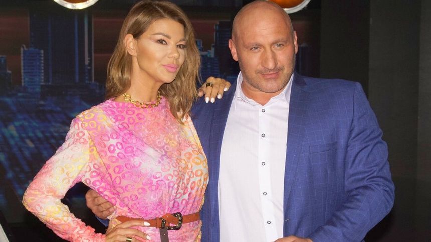 Edyta Górniak i Marcin Najman stoją na tle ciemnej sceny.