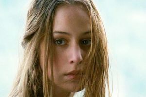 Zdjęcie przedstawia kobietę z długimi, rozpuszczonymi włosami, patrzącą w obiektyw.