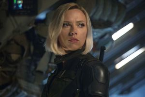 Kobieta w czarnym stroju z blond włosami, patrzy intensywnie, w tle techniczne wyposażenie.