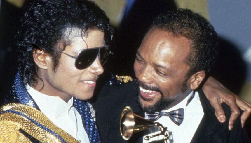 Michael Jackson i Quincy Jones podczas rozdania nagród Grammy, uśmiechają się, Jackson trzyma statuetkę