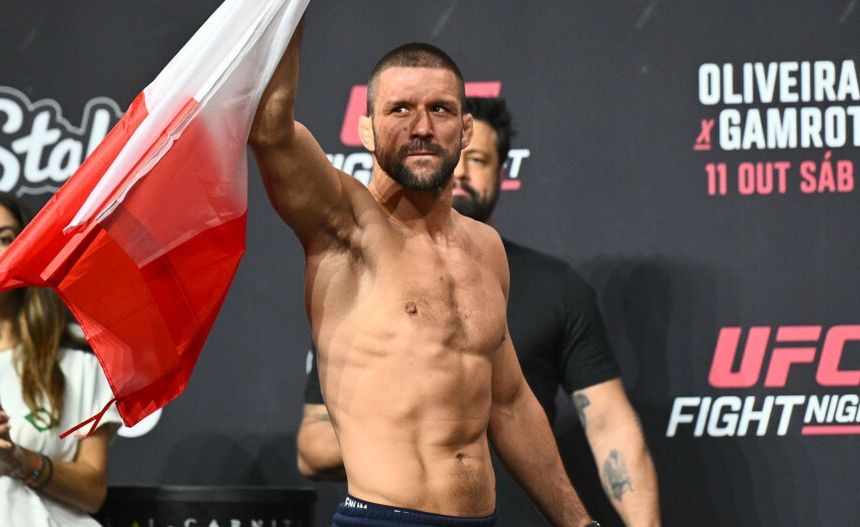 Mateusz Gamrot trzyma flagę Polski podczas ceremonii ważenia przed galą UFC.