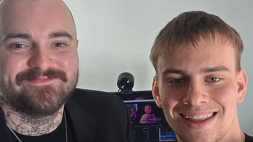 Bedoes i Łatwogang pozujący do zdjęcia w mieszkaniu z komputerem w tle.